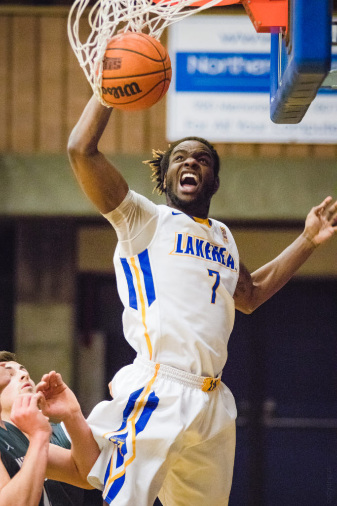 Action shot of a Lakehead University basketball player performing a slam dunk; high-intensity sports photography capturing athletic expression in Thunder Bay.
