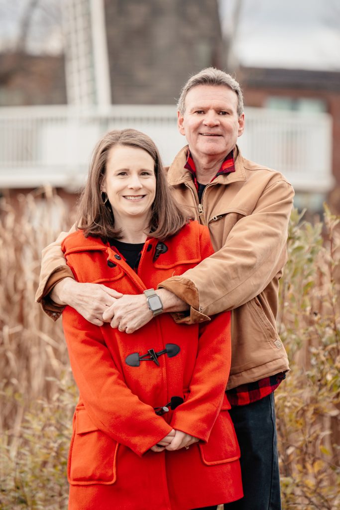 A portrait of a couple sharing a warm embrace at Friendship Gardens in Thunder Bay. The high-clarity shot features natural skin tones and soft lighting against a muted autumnal background, reflecting TbayAlive’s focus on authentic storytelling and capturing the genuine connection between individuals in the local community.